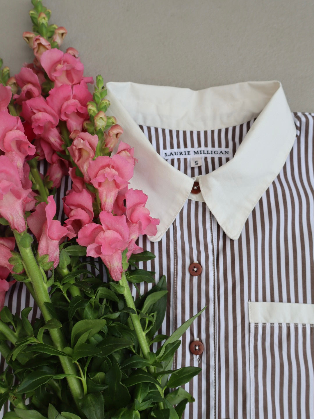 Close up of the Ruth shirt collar. An oversized brown and white stripe cotton shirt with white organic cotton contrast cuffs and collar and brown natural corozo nut buttons. 