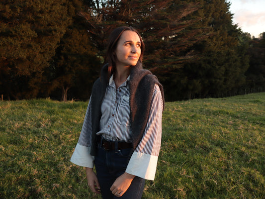 Woman wearing The Ruth shirt by Laurie Milligan in a New Zealand field